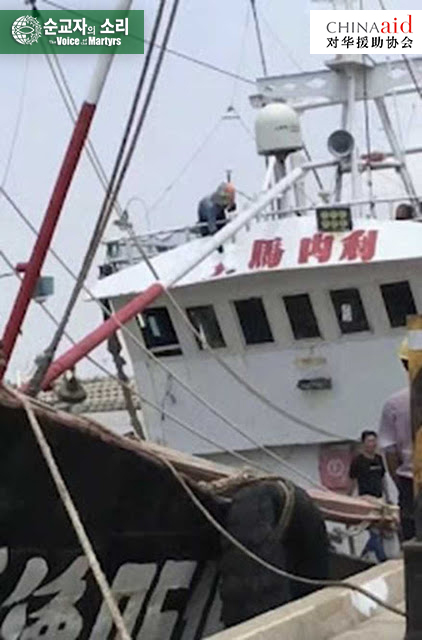 취산도 공산당의 용역 업체 직원이 한 어선에서 ‘임마누엘’이라는 표어를 지우고 있다.