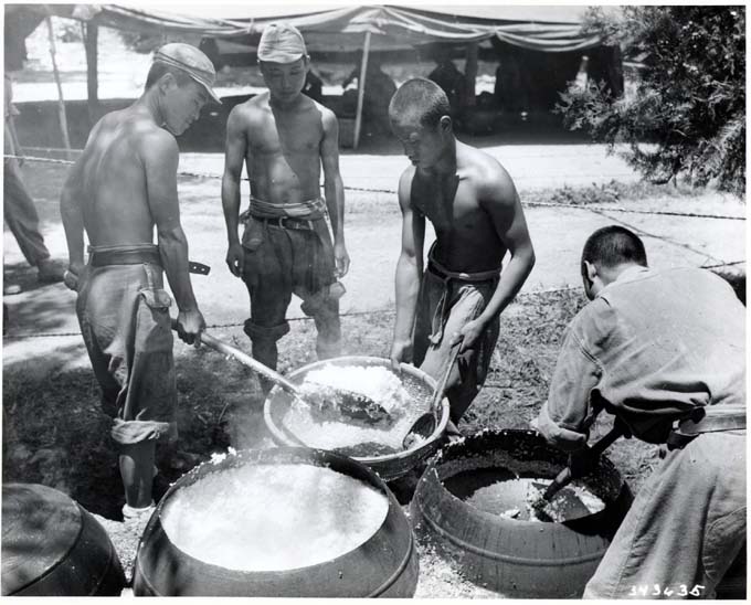 1950년 7월14일 전선에서 국군 취사병들이 임시로 가설한 가마솥에 밥을 지은 뒤 뚜껑을 열고 밥을푸고 있다.