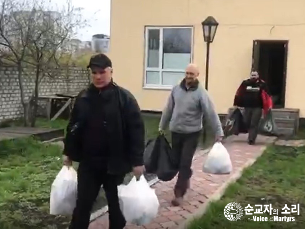 폴루닌 목사 사역팀이 키이우에 남아 있는 주민들에게 나눠줄 음식과 생필품이 담긴 봉지를 승합차에 싣고 있다.