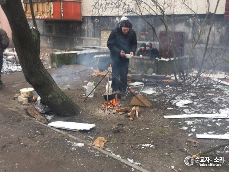 세베르도네츠크의 한 아파트 건물 잔해 앞에서 이웃을 위해 음식을 준비하고 있는 ‘변화산 교회’ 성도들