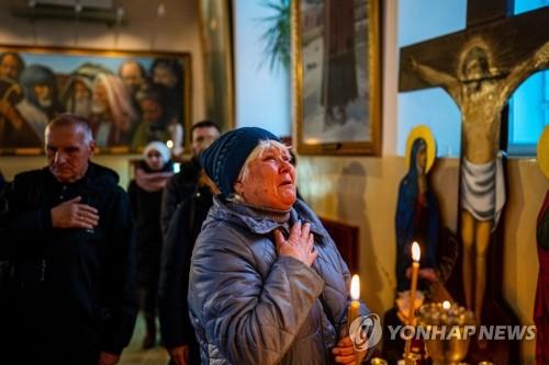 성탄절에 성당서 기도하는 우크라이나 정교회 신자(헤르손 AFP=연합뉴스) 러시아의 우크라이나 침공이 계속되는 가운데 25일(현지시간) 우크라이나 남부 헤르손의 한 성당에서 한 여성 신자가 성탄절 미사 도중 기도하고 있다. 정교회를 믿는 우크라이나는 세계표준인 '그레고리력'과 13일 차이가 나는 '율리우스력'을 사용하기에 그동안 매년 1월 7일을 성탄절로 기념해왔다. 하지만 반러정서가 강해지면서 12월 25일에 성탄 미사를 진행하는 경우가 적지 않게 됐다. 2022.12.26.