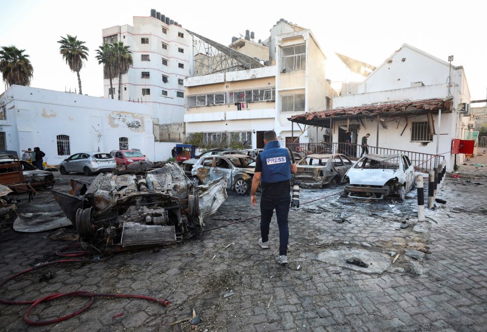 지난 17일(현지시간) 폭발로 불에 탄 팔레스타인 가자지구 북부 가자시의 알아흘리 아랍 병원 주차장으로 기자가 걸어가고 있다. 2023.10.21[로이터 연합뉴스 자료사진. 재판매 및 DB 금지]