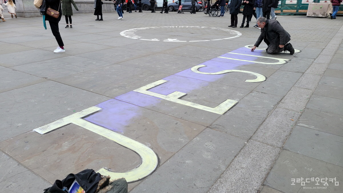 트라팔가 광장(Trafalgar Square) 바닥에 맨손으로 JESUS를 쓰고 있는 남성 / 2023년 2월 12일 / 사진@ 김대진/ 코닷DB