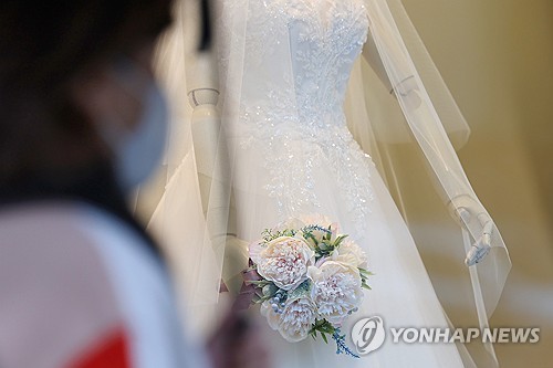 신혼부부 110만에서 103만쌍으로 감소/12월 11일 서울 마포구 아현동 웨딩거리 한 웨딩드레스 판매점 앞을 시민들이 지나가고 있다.