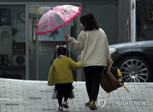 서울 시내에서 한 어린이가 엄마와 어린이집에 가고 있다